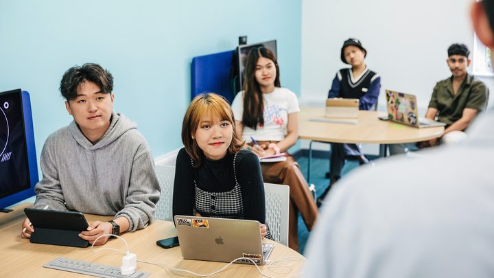 Students inside classroom listening to the teacher