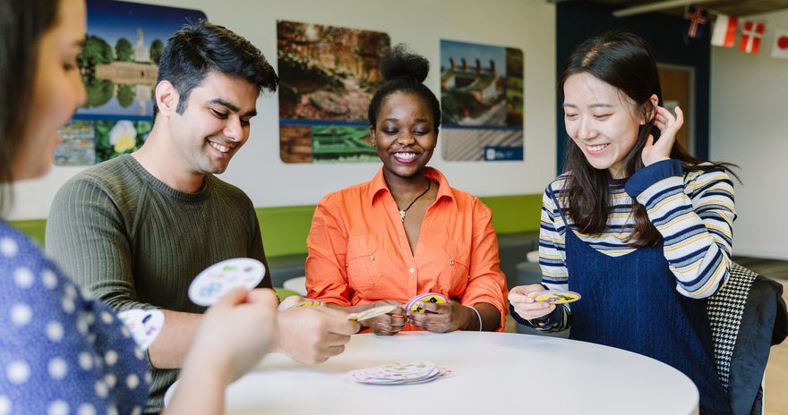 A group of students playing card game in shared area