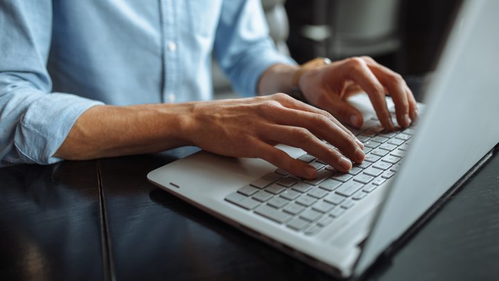 Close up of hands typing on laptop