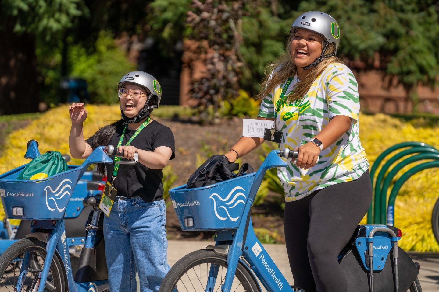 Two smiling students on public bikes at the University of Oregon