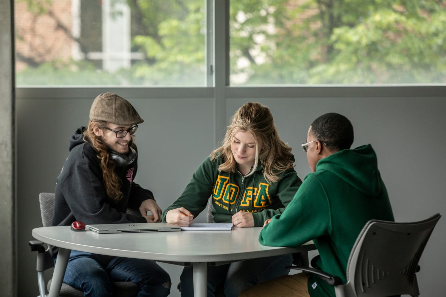 Three engineering students studying together at a round-table