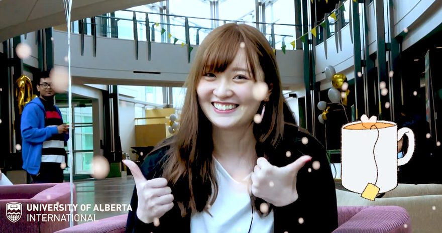 International student at the University of Alberta giving two thumbs up with a smile