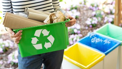 Student holding a recycling bin