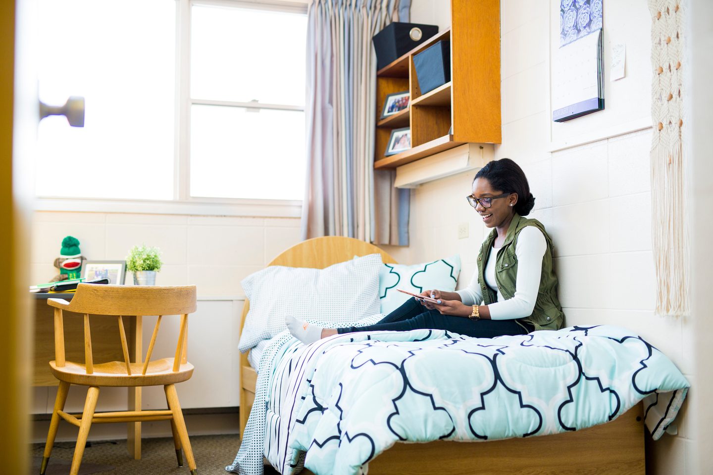 Student siting on her campus dorm's bed at the U of A