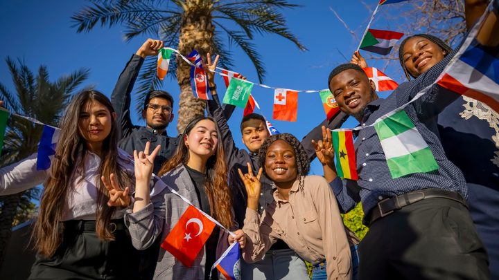 A group of students holding a variety country flags at Arizona State University to represent multiculturalism