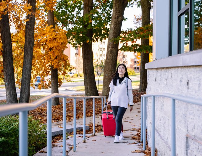 A Storrs students carrying her luggage